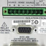 Close-up of a green terminal block on a Keithley 2308 device with serial and power connections.