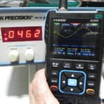Oscilloscope displaying waveform with BK Precision 4011A signal generator in background.